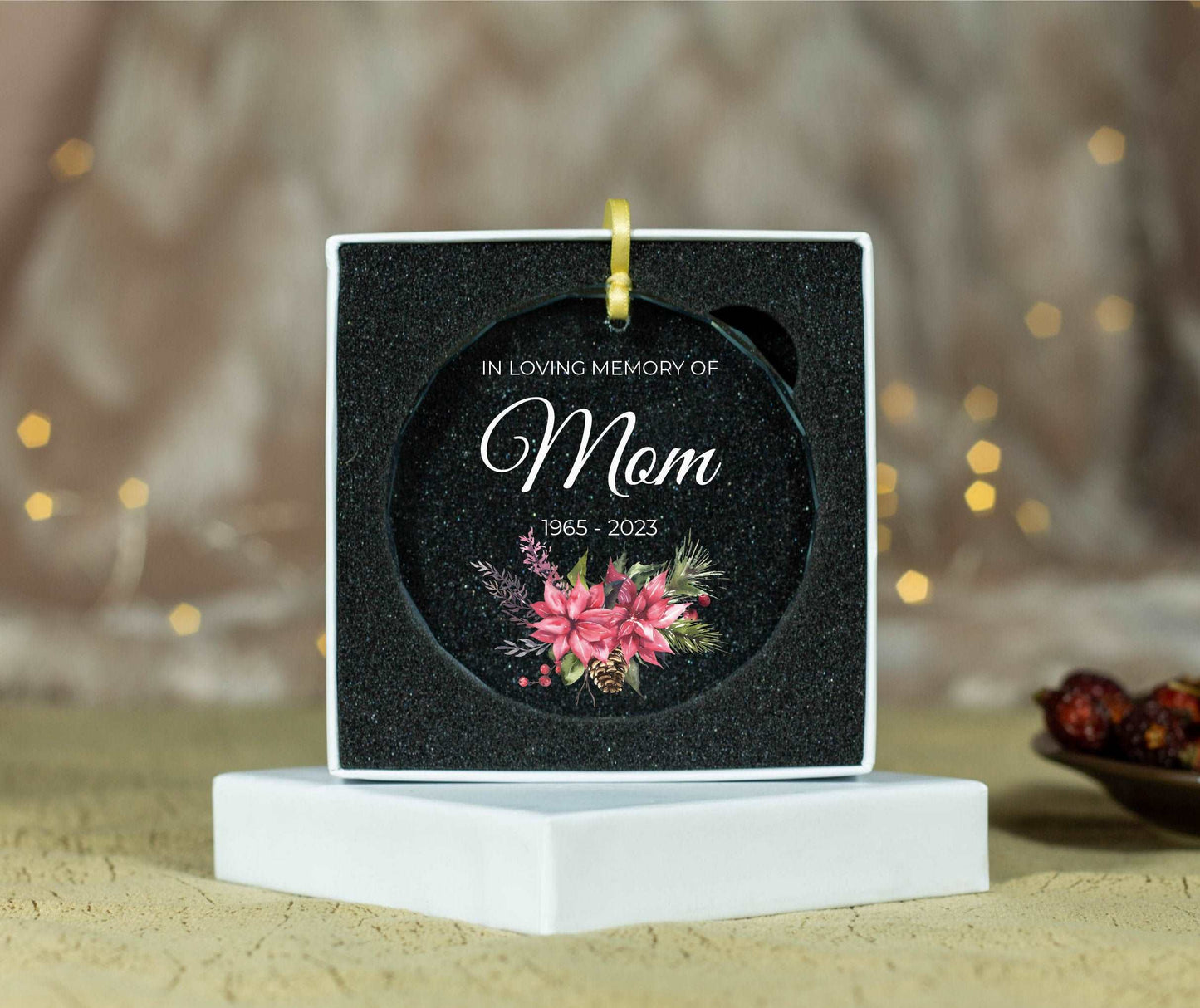 a memorial ornament with a pink flower on it