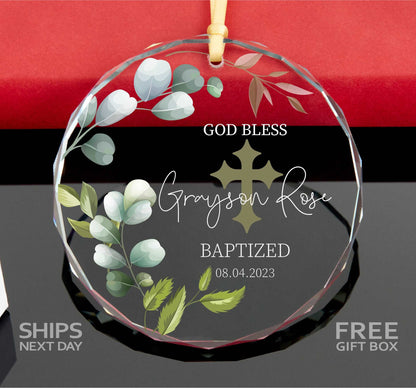 a glass ornament with a cross and flowers on it