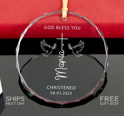 a glass ornament with a cross and two doves on it