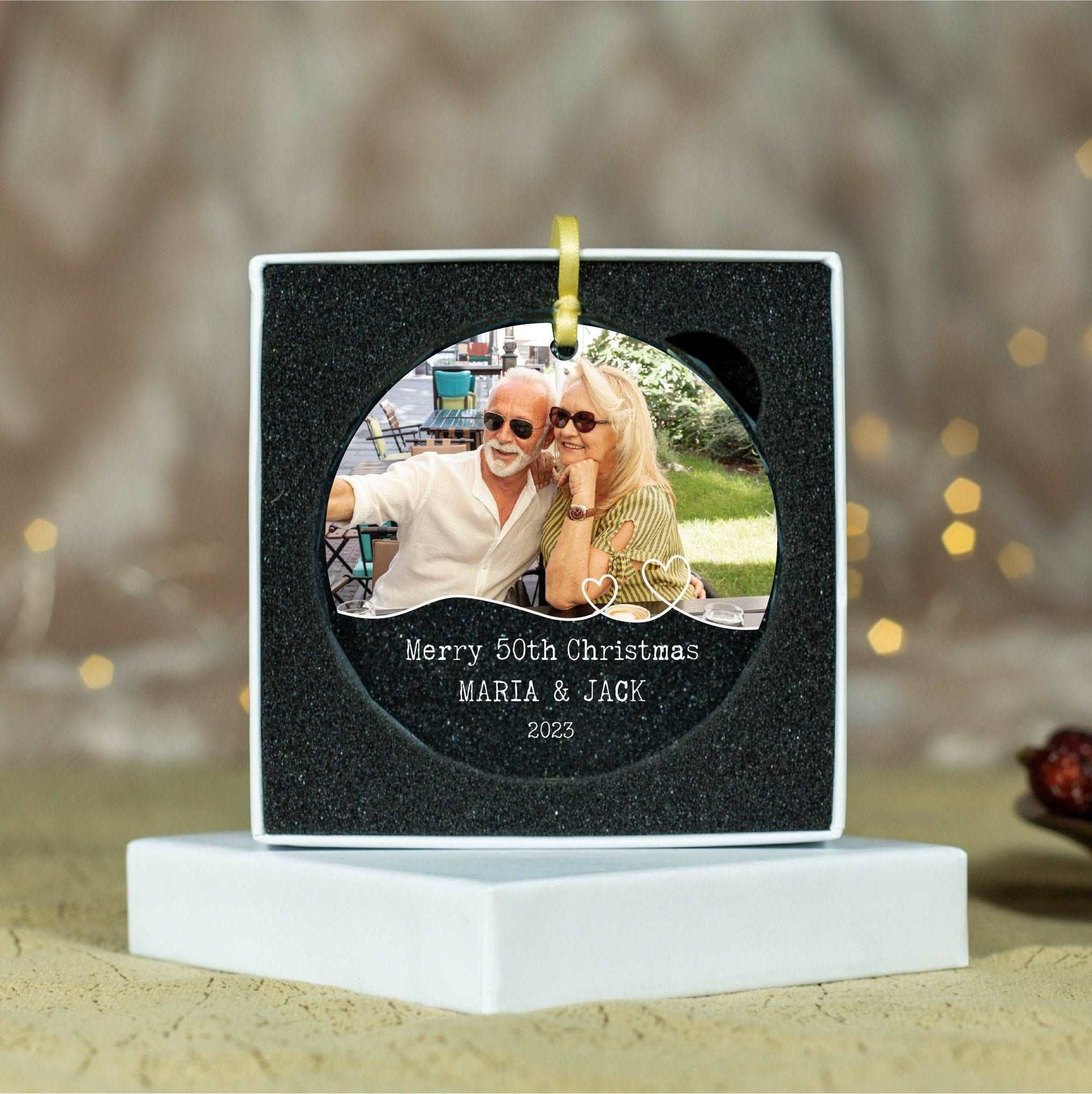 a picture of a couple on a christmas ornament